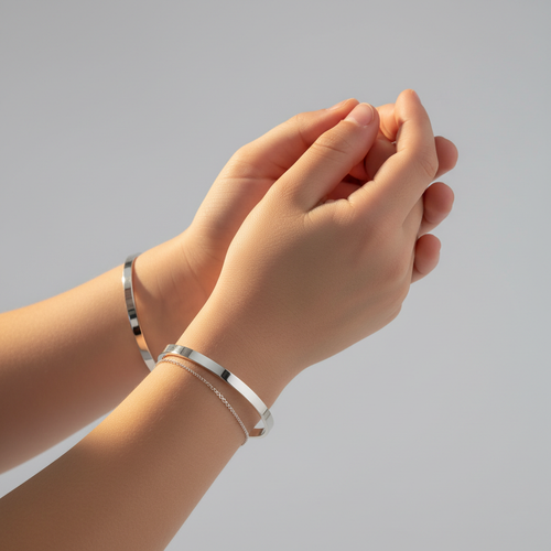 Kinderhanden met zilveren graveerbare armbanden